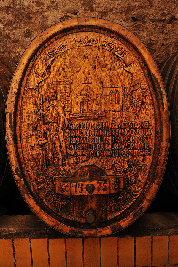 Kunstvoller Fassboden aus dem Weingut Hildegardishof in Ockenheim (zu sehen ist St. Rochus und die Rochuskapelle in Bingen) | Auf dem Fass steht ohne Satzzeichen geschrieben: St. Rochus schütz mit starker Hand die Bürger Bingens und ihr Land Schütz uns vor Pest wie eh und je und vor dem Durst auch er tut weh
